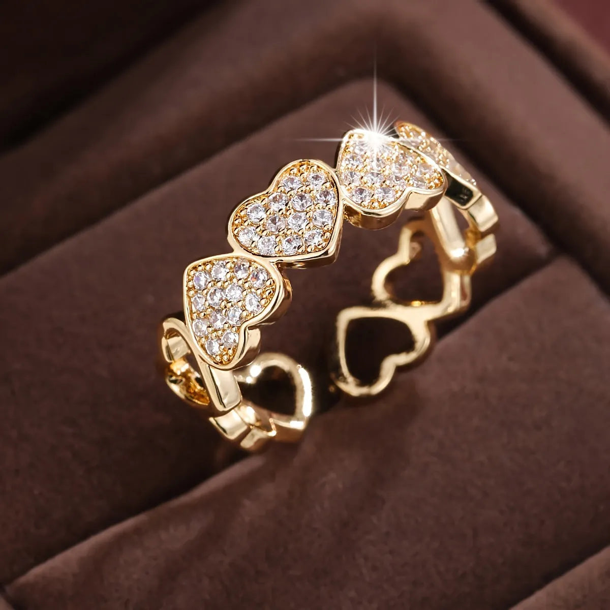 Gold and silver adjustable heart-shaped couples ring on a small finger.