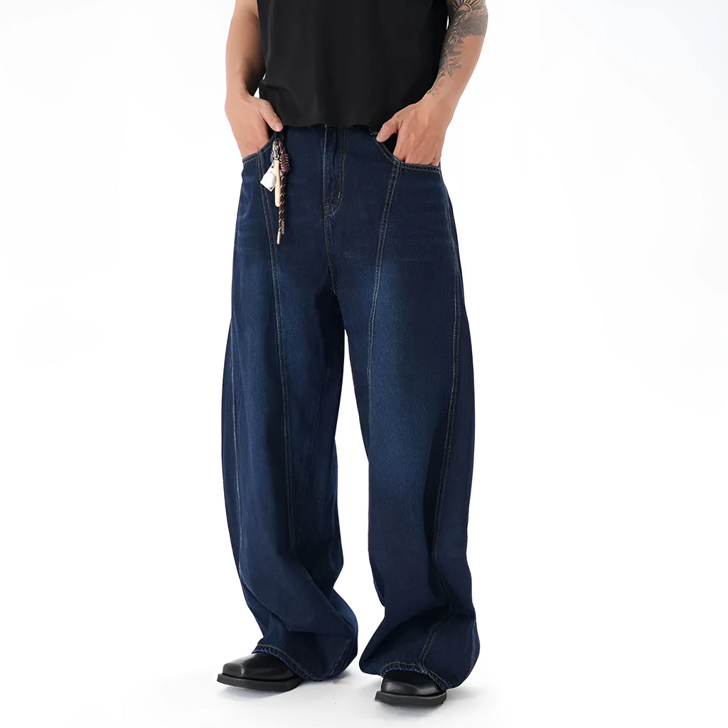 Dark blue distressed wide leg jeans with a machete cut design on a denim fabric.