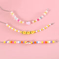Colourful plastic bead pet necklace in peach, rainbow or small flower pattern with adjustable XS or S size options.