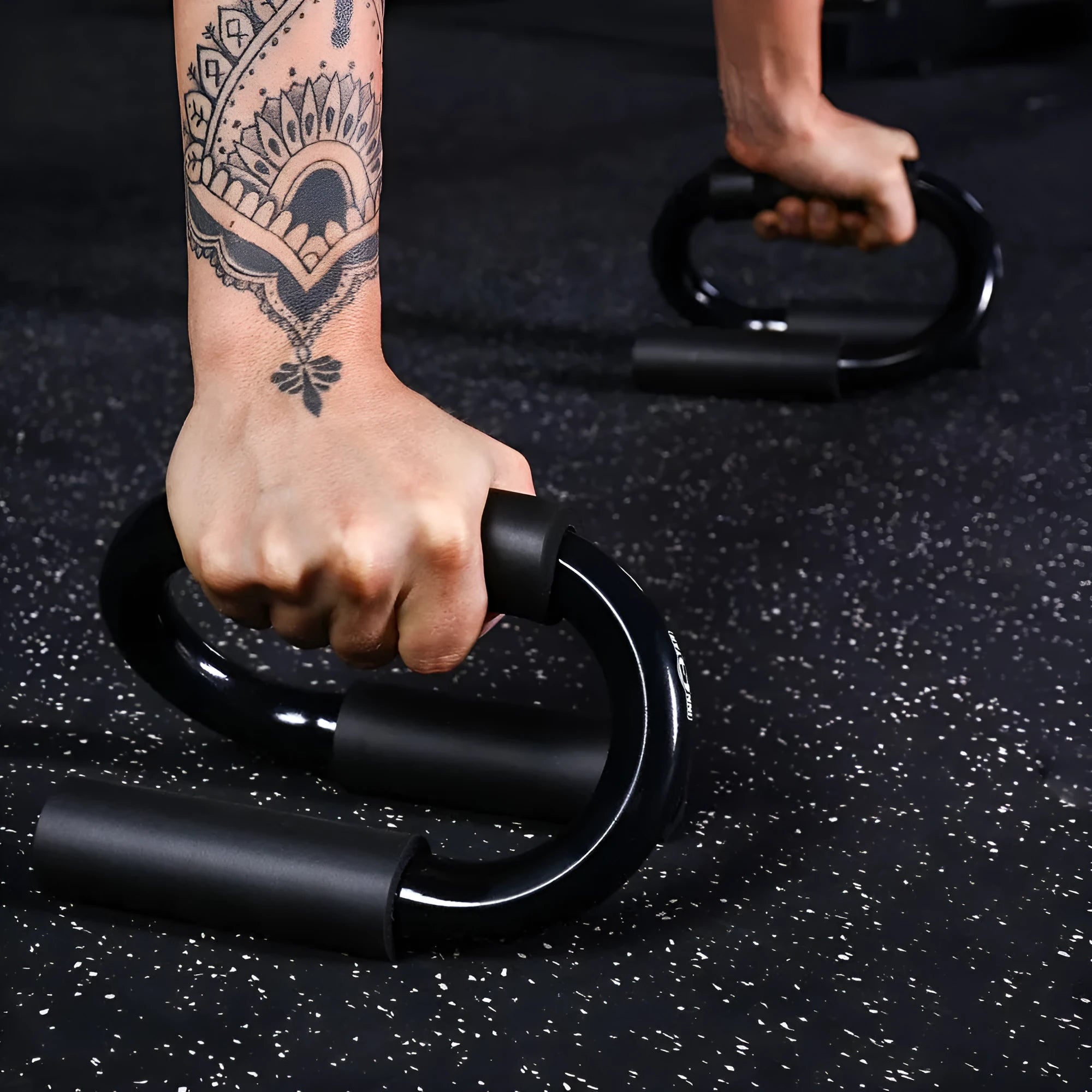 Black S shape push-up bracket rack on a home gym floor