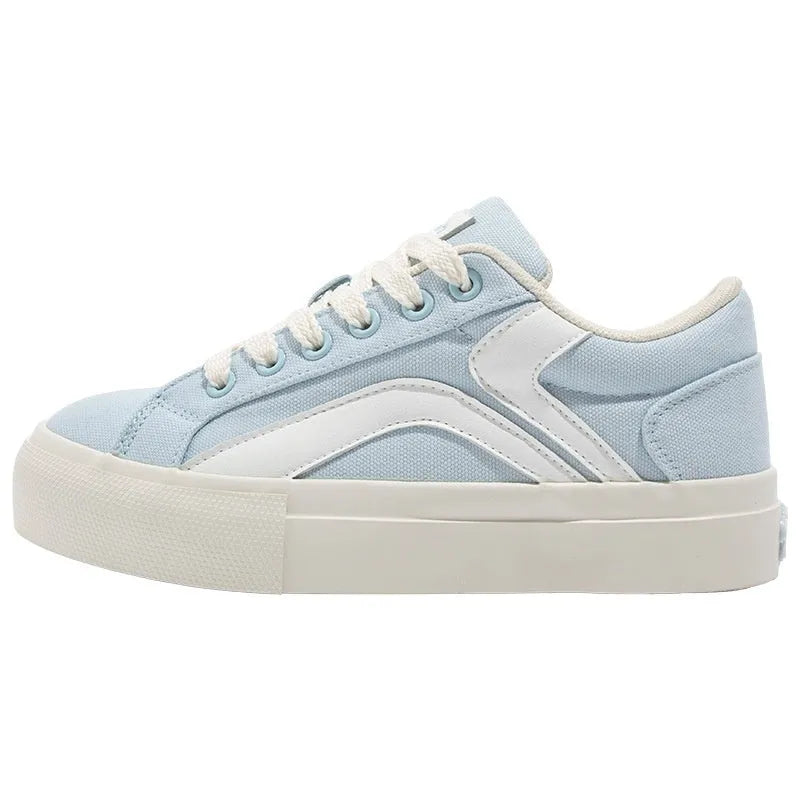 Women's low-top board shoes in a black and white colour combination, showing round toe and front lace-up design.