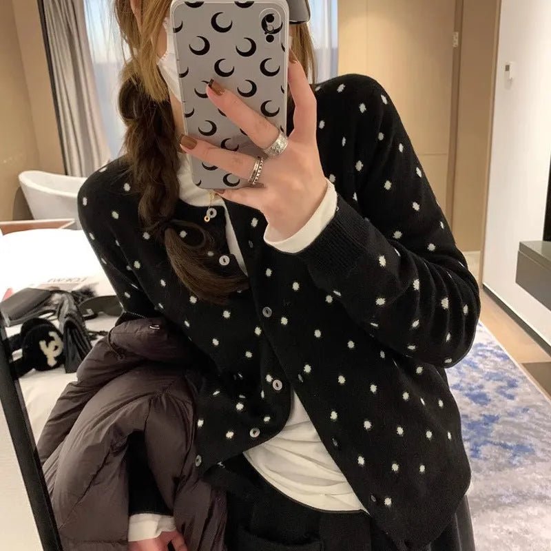 Women's grey and black Korean-style loose knit cardigan with crochet flower detail on the front.