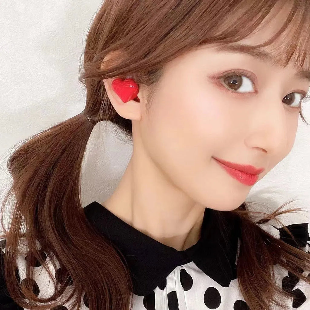 Heart-shaped wireless Bluetooth earphones in red and pink colours with charging cable