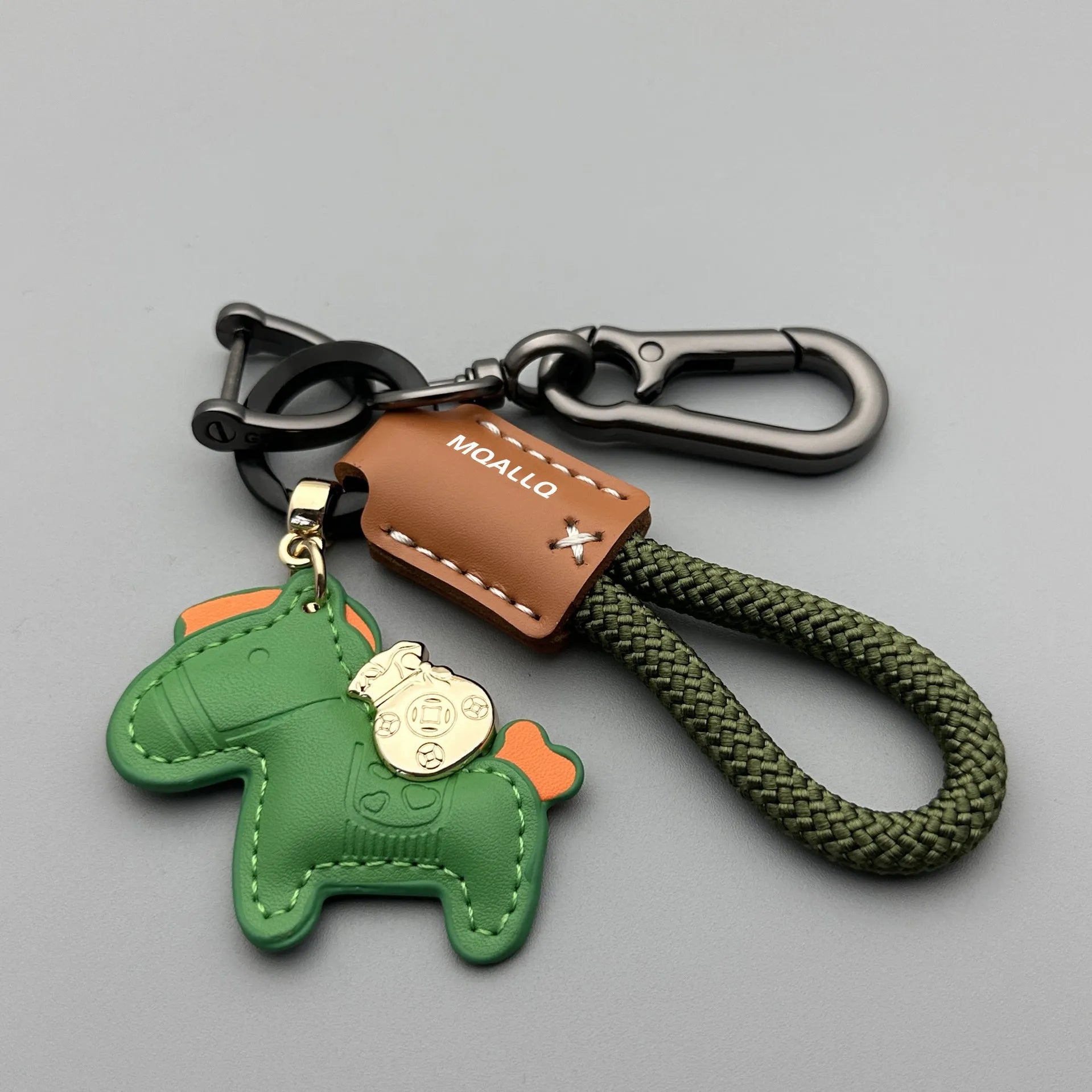 Handmade brown cowhide leather key ring pendant with a gold-toned zinc alloy pony belt buckle and green flanelle rope.
