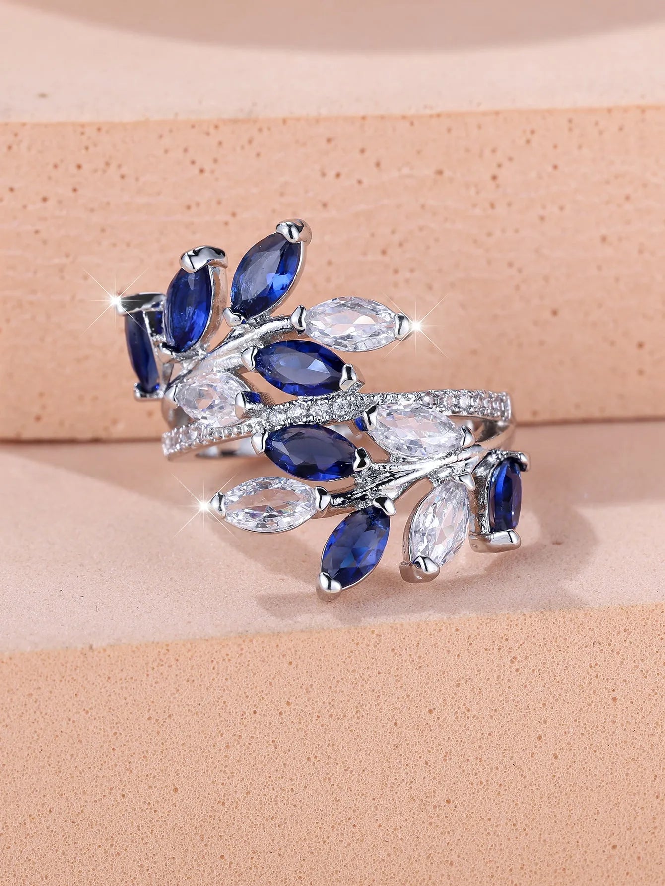 Adjustable open-ended leaf-shaped ring with zirconia stones on a copper band.