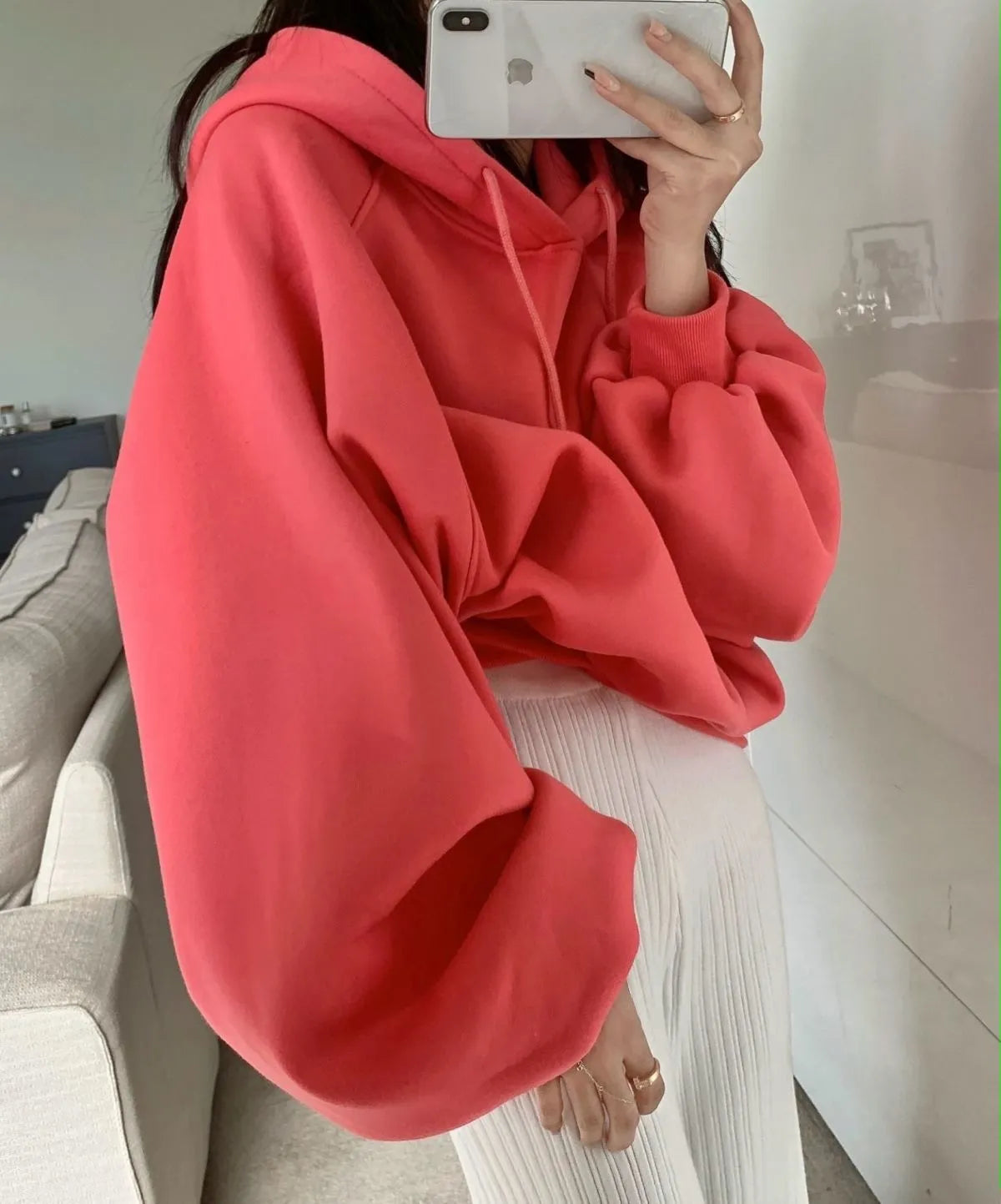 Women's loose watermelon red mulberry silk hooded pullover sweater on a hanger.