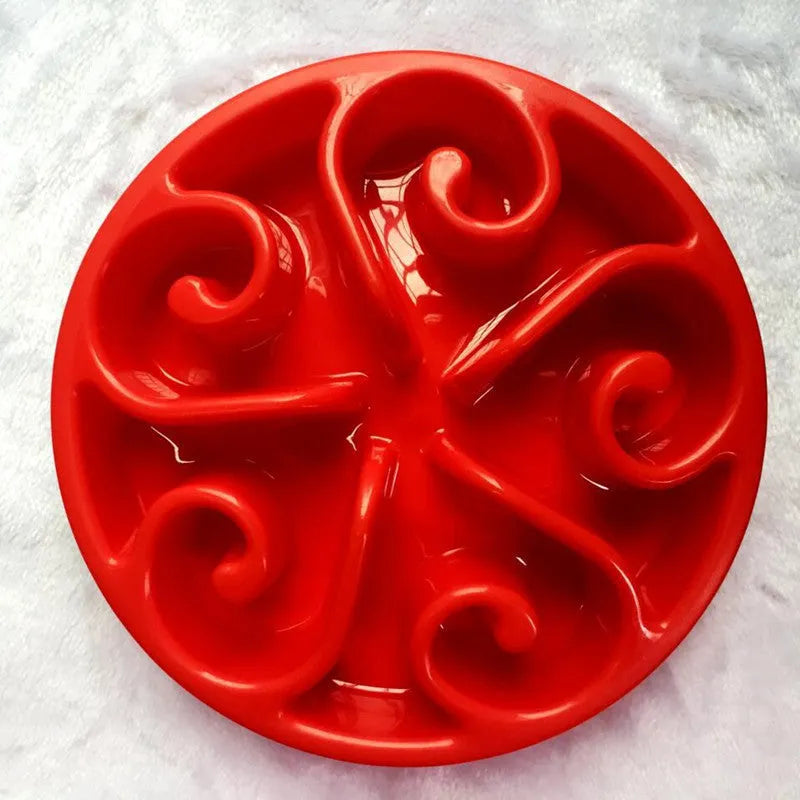 A coloured slow feeder dog bowl with a maze pattern design and a wide non-slip base.