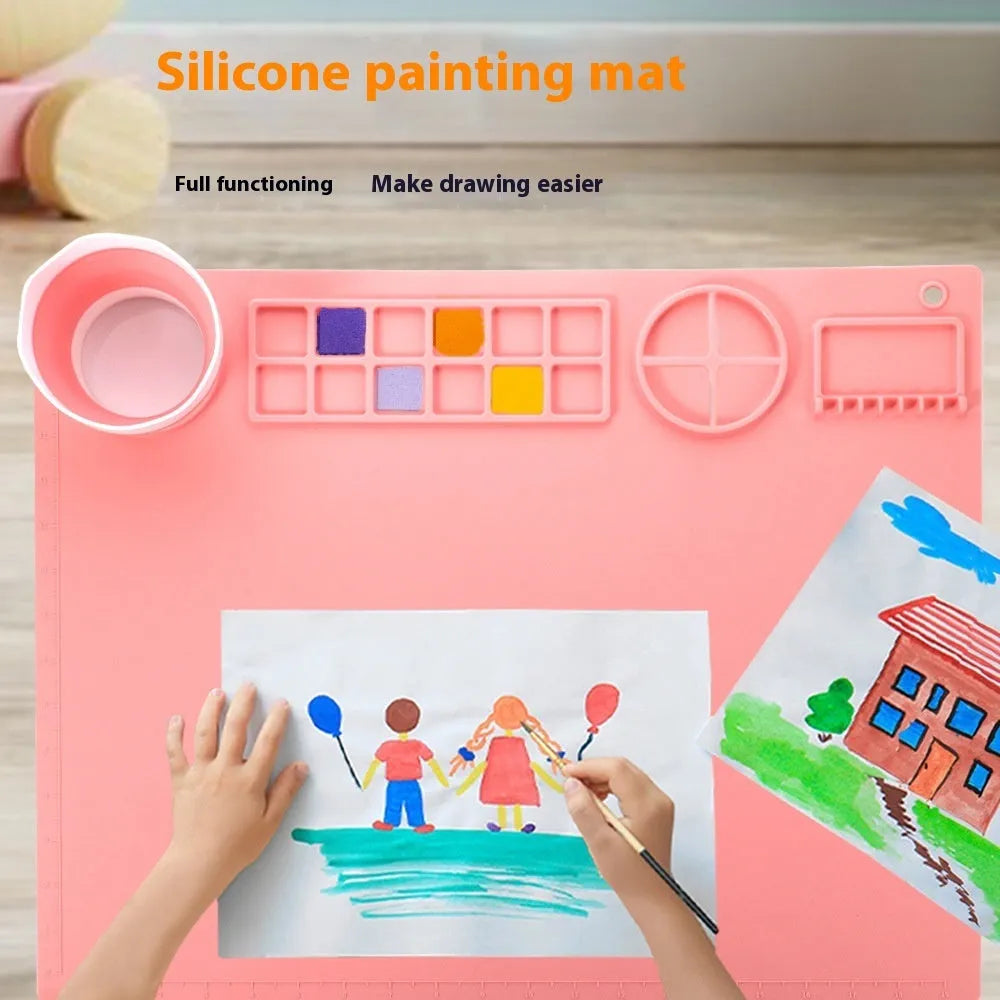 Light blue silicone painting mat measuring 50 by 40 centimetres with two round paint wells.
