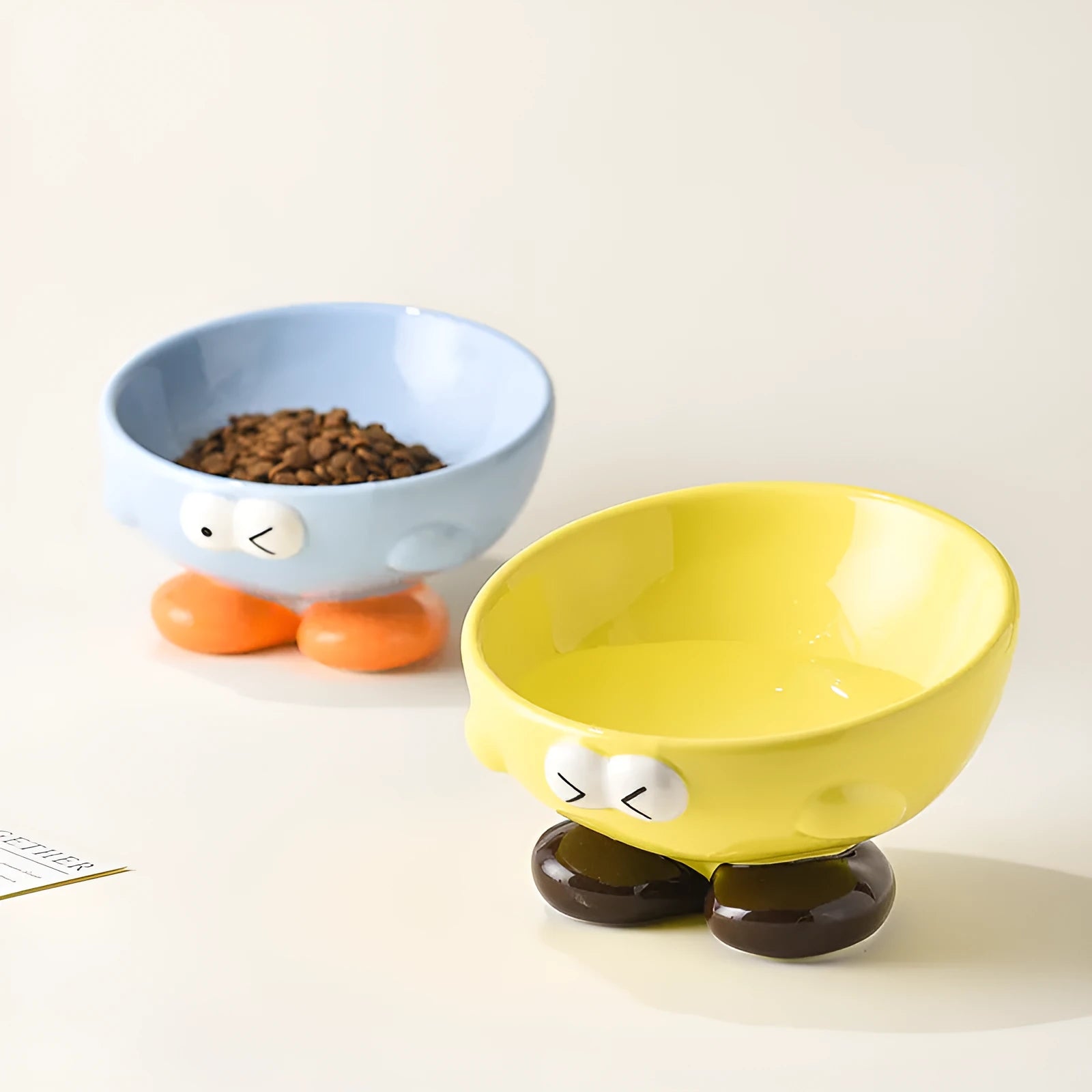 Blue oblique tall ceramic pet bowl with a cute expression design for cats and dogs.