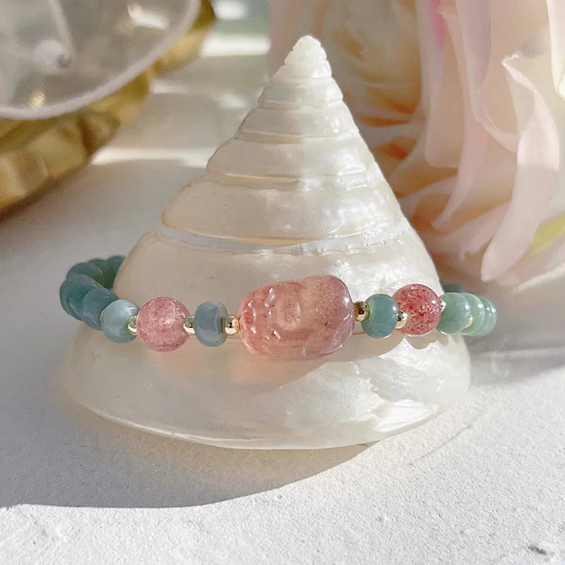 Blue-toned jade bracelet with gourd and peace buckle charms and strawberry quartz accents