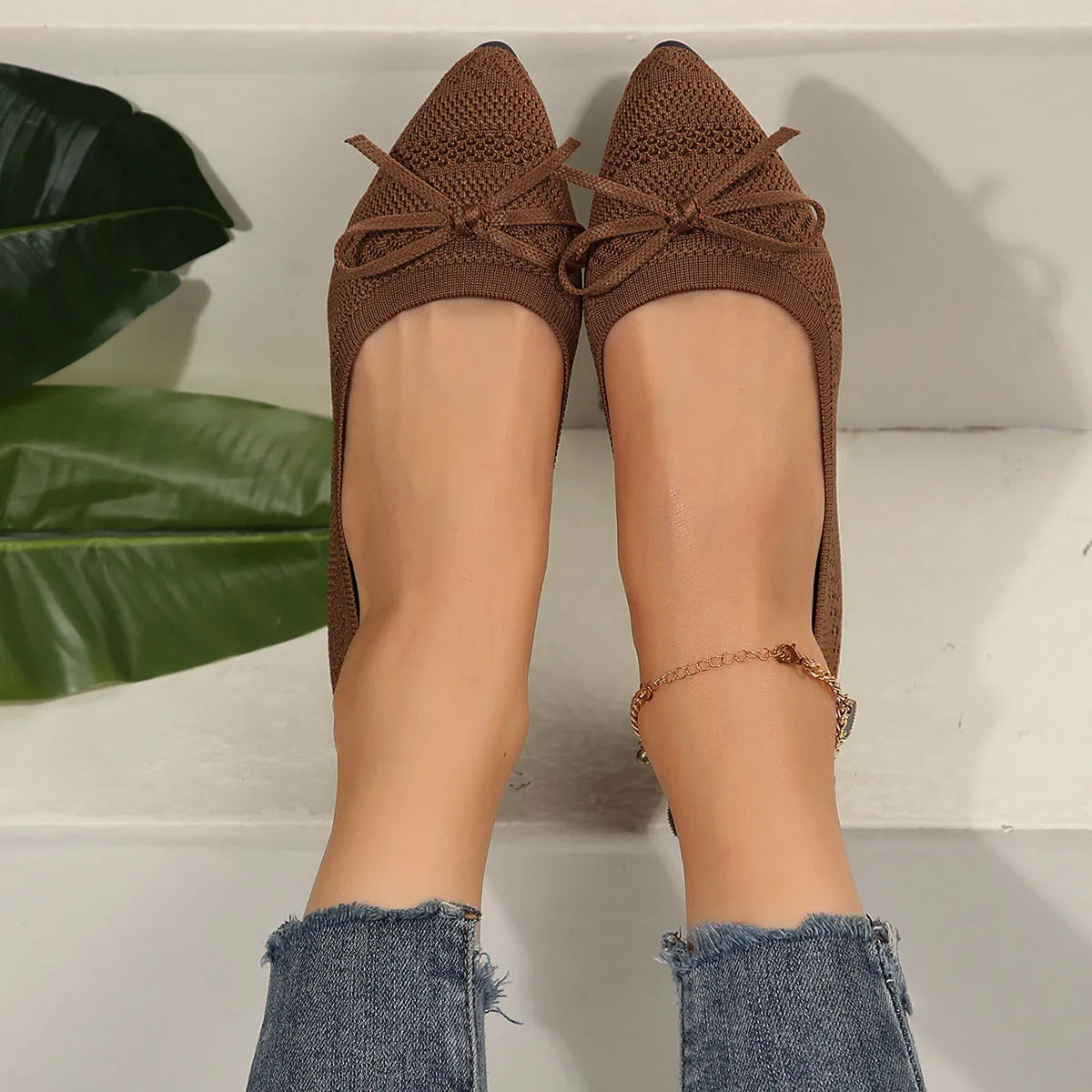 Women's knitted loafers with bow decoration in various colours showing flat rubber soles