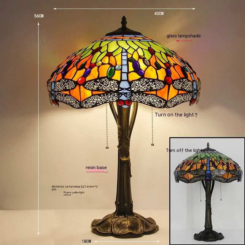 Stone Tiffany dragonfly table lamp in European retro style on a wooden table.
