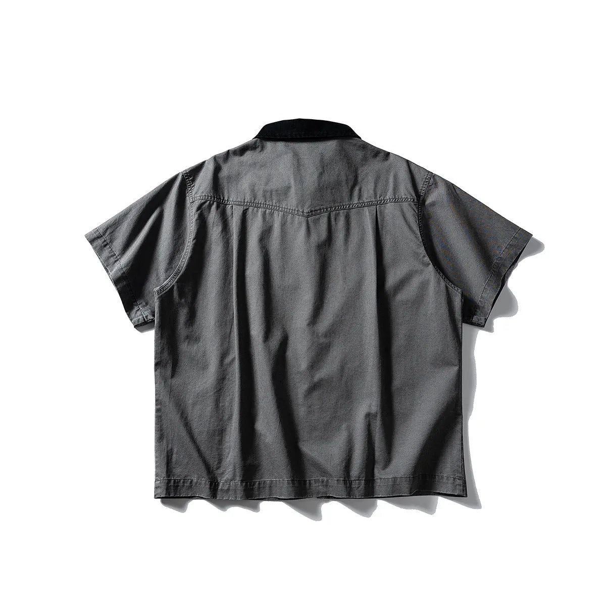 A loose grey or khaki cotton short-sleeved overall shirt, shown as an oversized cardigan style.