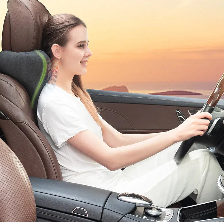 Dark grey memory foam car neck pillow on a car headrest.