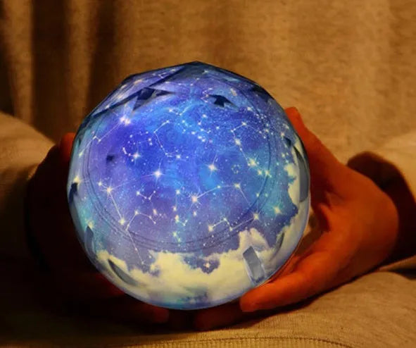 Galaxy projector lamp with diamond-shaped shell showing earth pattern on a table