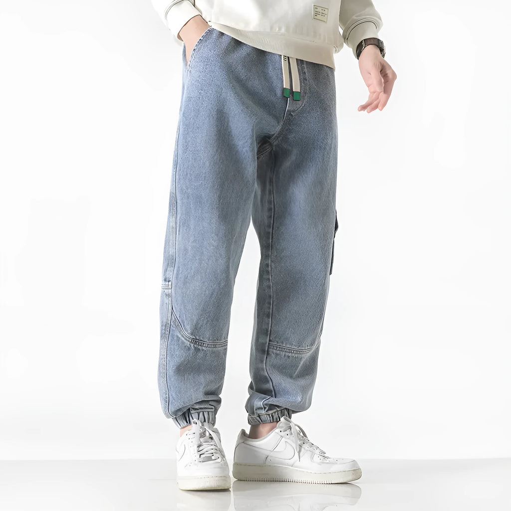 Men's loose-fit tapered cotton trousers in black, shown on a hanger