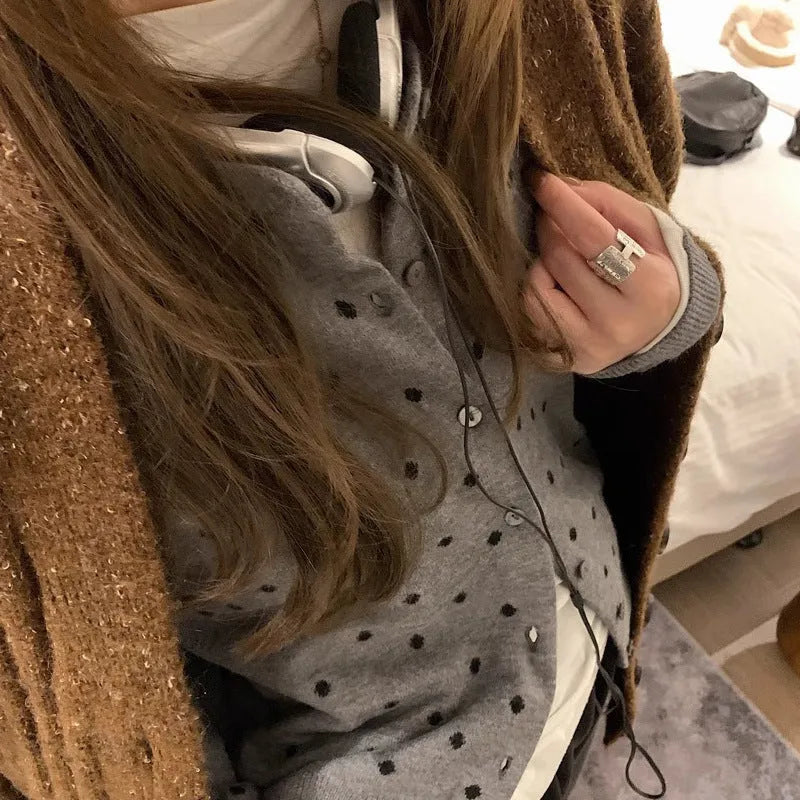 Women's grey and black Korean-style loose knit cardigan with crochet flower detail on the front.