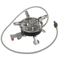 Silver portable split camping stove with foldable legs and a long black hose, on a grass background.