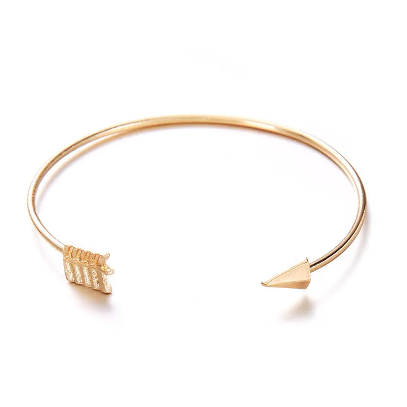 Women's gold vintage cuff bracelet with arrow and knotted design on wrist