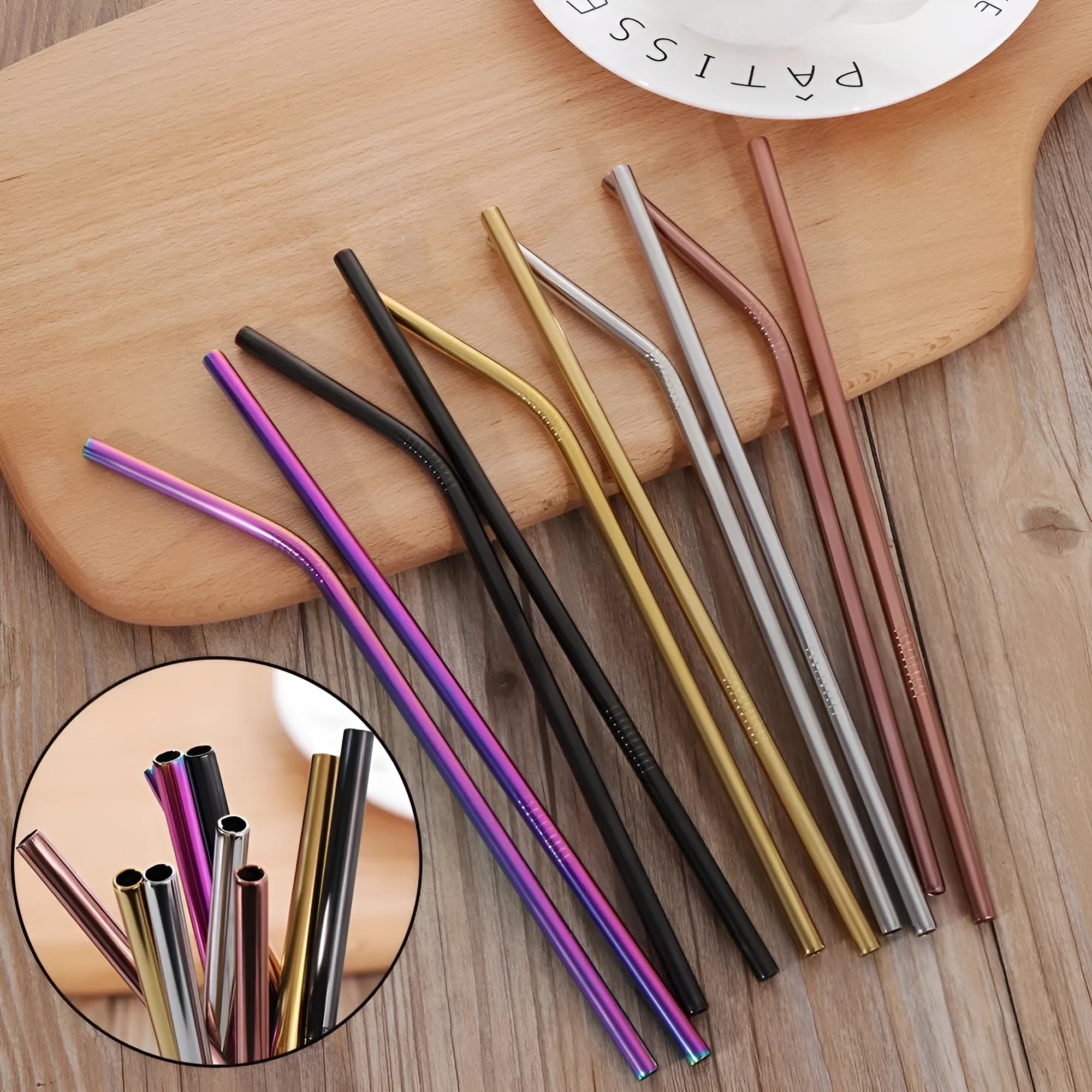 Set of reusable stainless steel straws in straight and bent styles with a cleaning brush on a table.
