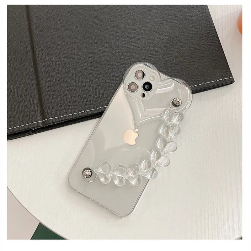 Transparent iPhone case with a love heart charm on a chain, on an iPhone.