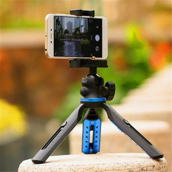 Black desktop tripod stand holding an iPhone X mobile phone.