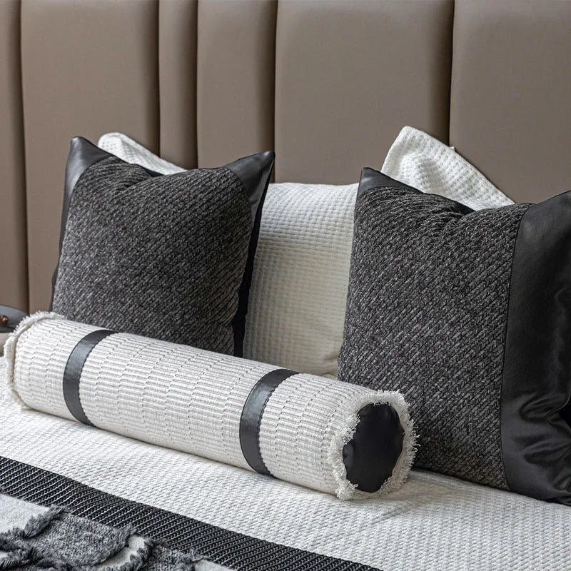 Modern grey and white plaid bed runner blanket set with a matching pillowcase and round pillow on a double bed.
