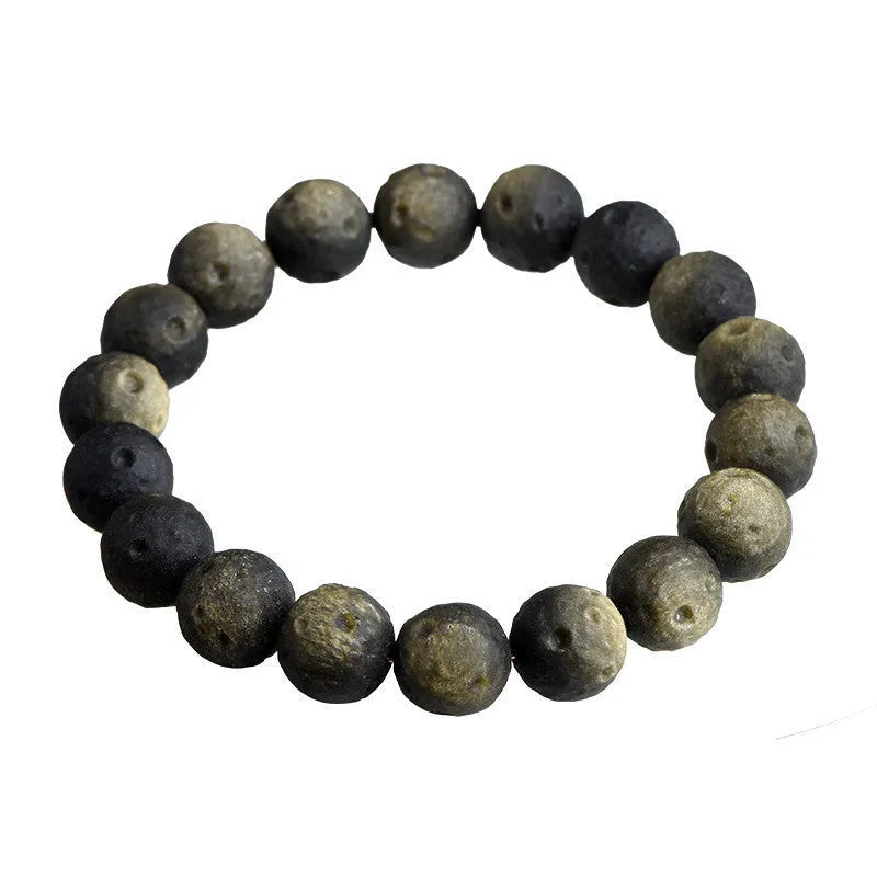 Natural obsidian crater ball bracelet with textured beads on a wrist, showing silver stone meteorite colour variant.