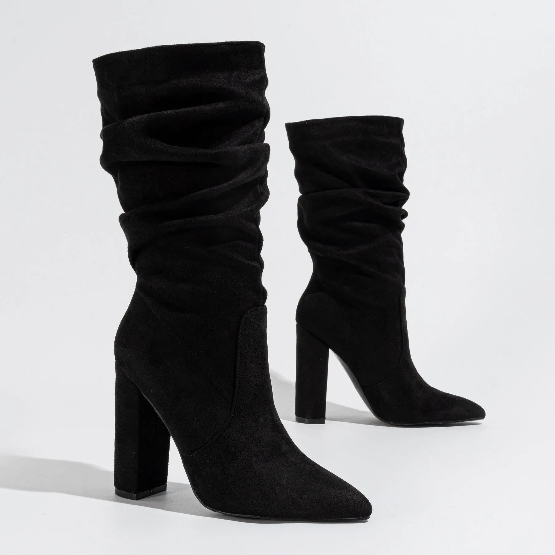 Black suede women's boots with a chunky high heel and pointed toe, shown on a mid-calf length.