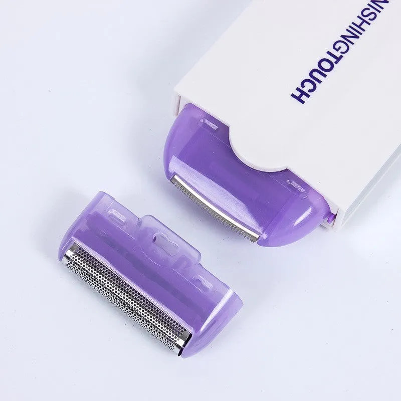 White rechargeable electric hair removal instrument with foil head and cleaning brush on a table.