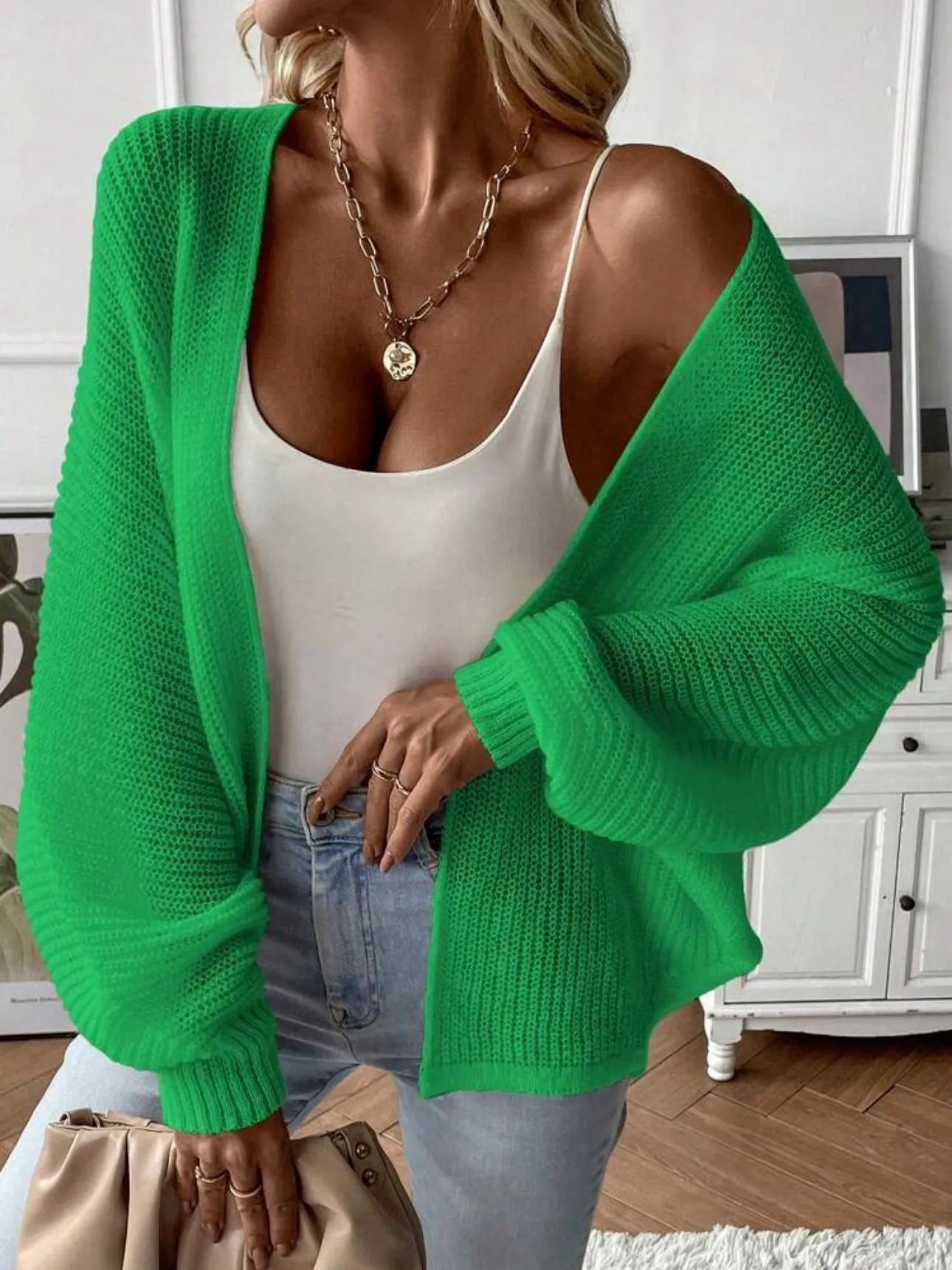 Loose-fitting women's cardigan with batwing sleeves in a solid colour, shown on a model.