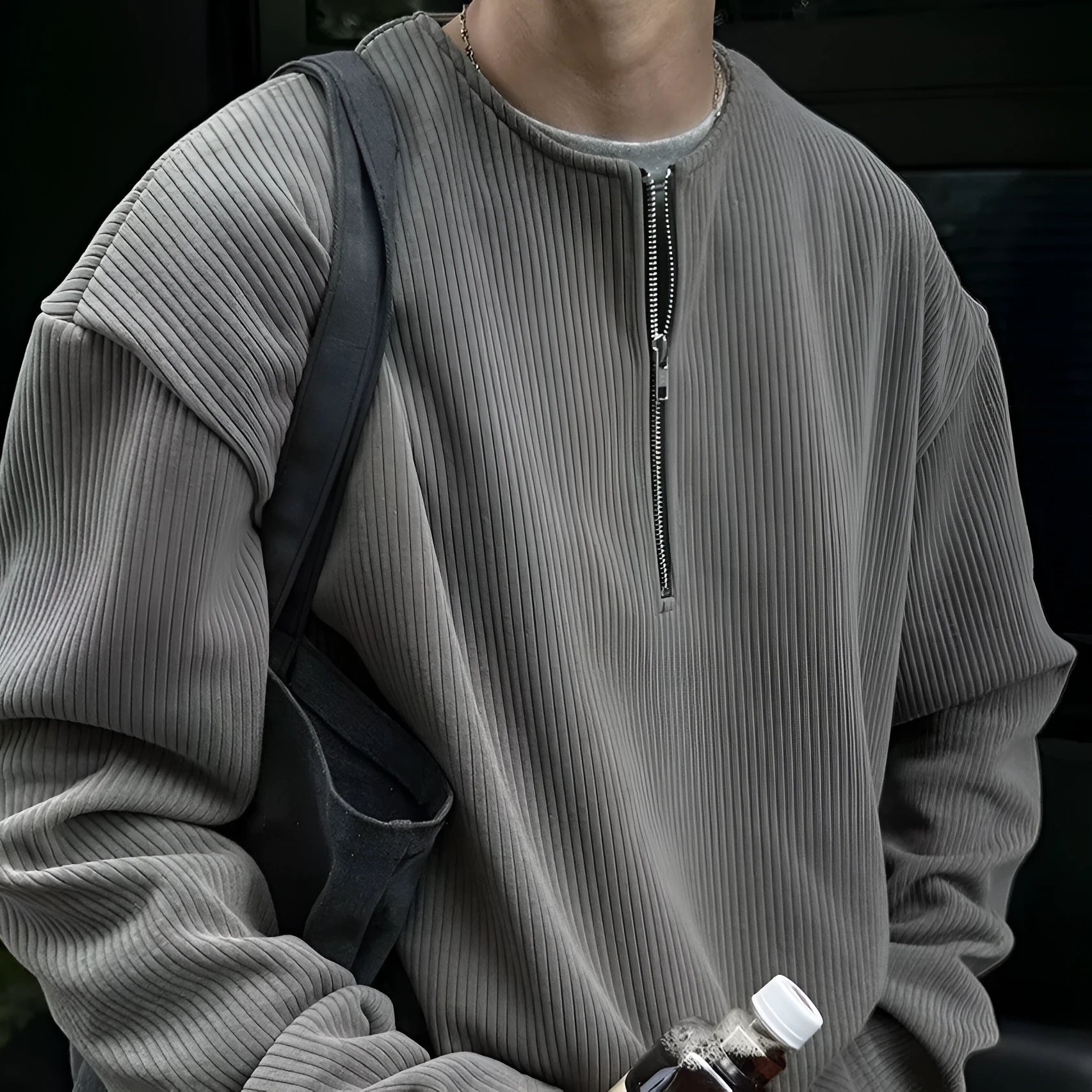 A grey loose-fitting long sleeve women's pullover top hanging flat.