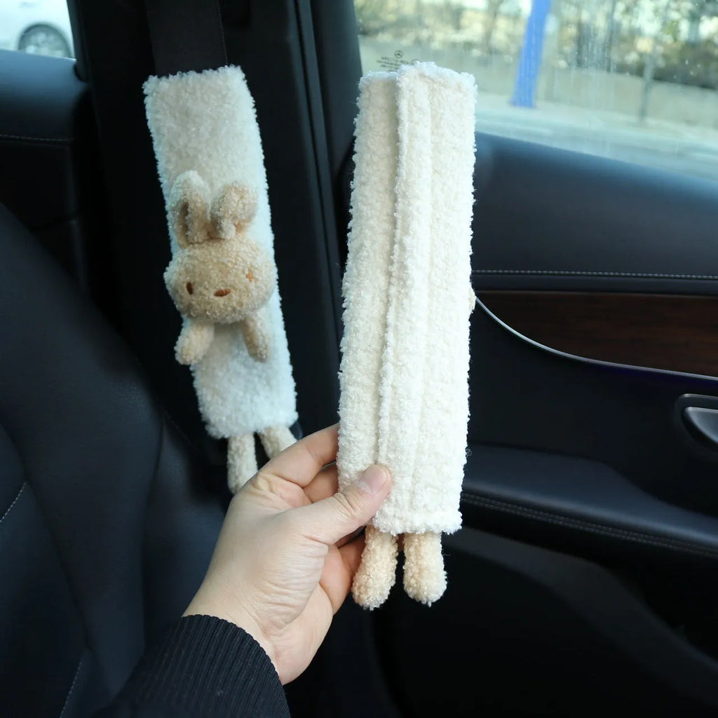 Plush lamb wool car seatbelt shoulder protector with cartoon rabbit and bear designs.