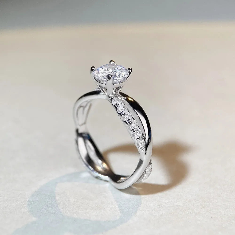 Geometric twisted silver band ring with 1 karat moissanite stone in four-claw setting, side view showing cross details