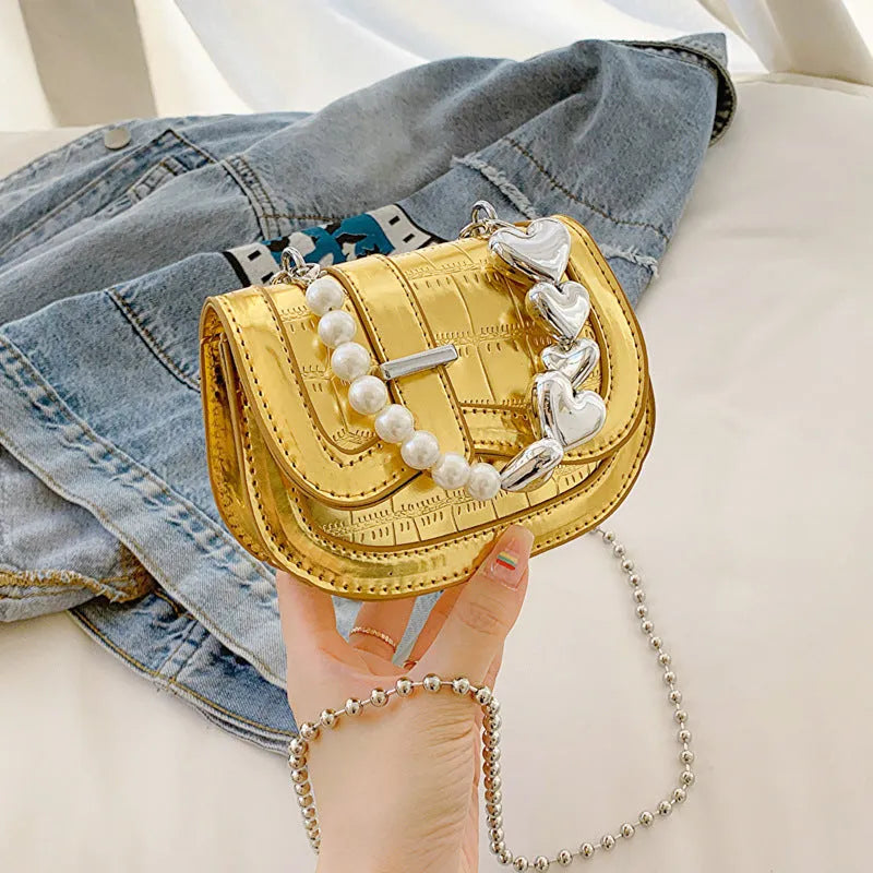 Laser pearl finish mini tote saddle crossbody bag in a choice of colours, shown with a single strap and structured square shape.