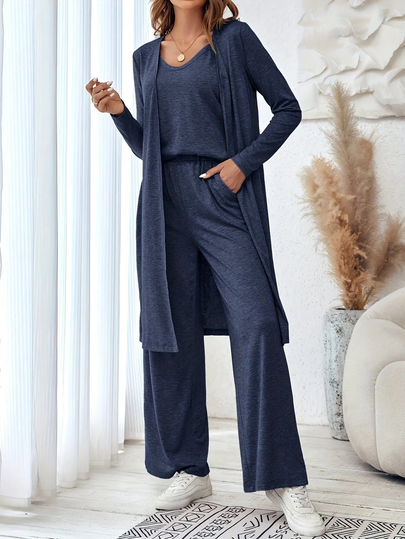 Blue women's three-piece casual suit set with sling top, cardigan, trousers, and suspenders on a hanger.