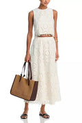 White women's sleeveless top and embroidered long skirt suit set on a hanger.
