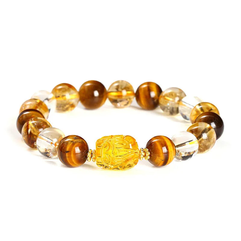 Close-up of a yellow tiger's eye and citrine bead bracelet with a geometric pi xiu charm on a wrist.