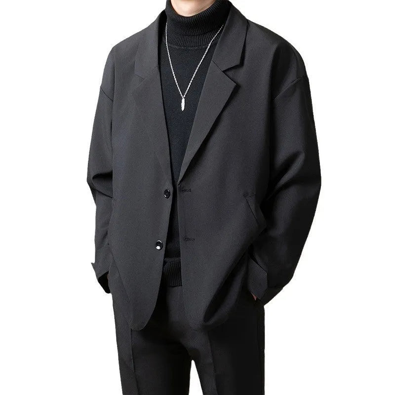 Man wearing a loose fit casual blazer in a light business style, available in black, grey, apricot and brown.
