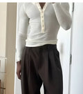 Men's cream apricot coloured ribbed long sleeve henley top with three-button front.