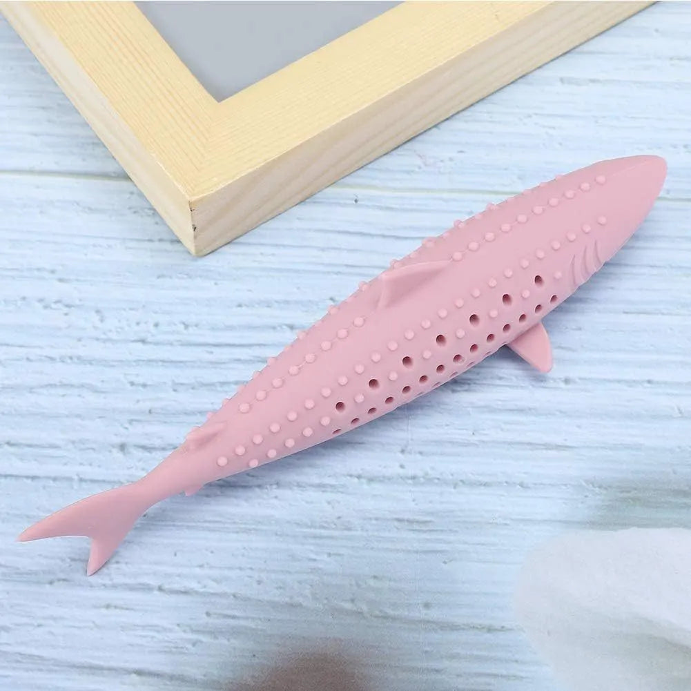 Green dolphin-shaped silicone cat chew toy with side holes on a white background