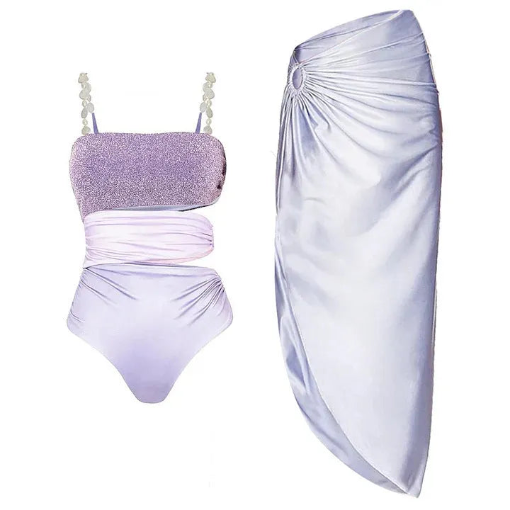 Purple one-piece swimsuit and matching wrap skirt set on a hanger.
