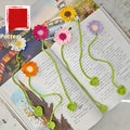Hand-crocheted white wool bookmark with a small daisy, showing its textured four-strand milk cotton construction.