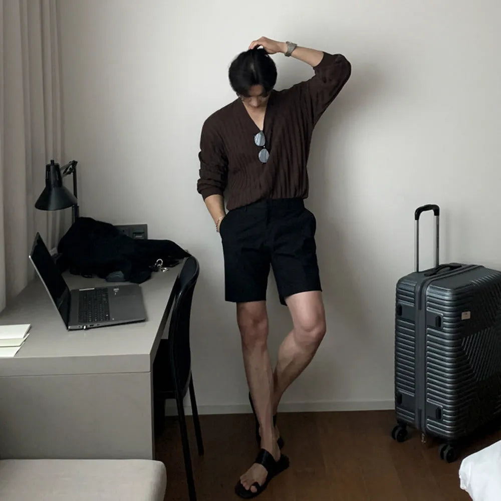 Man wearing loose straight-cut casual polyester shorts in a solid colour.