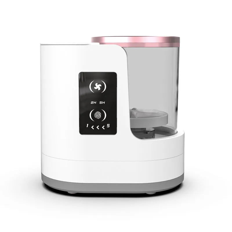 White electric makeup brush cleaner with drying chamber on a table, next to makeup brushes.