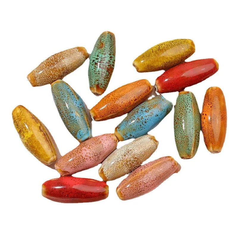 Assorted ceramic bullet beads in pink, yellow, blue, red, coffee, green, and orange colours