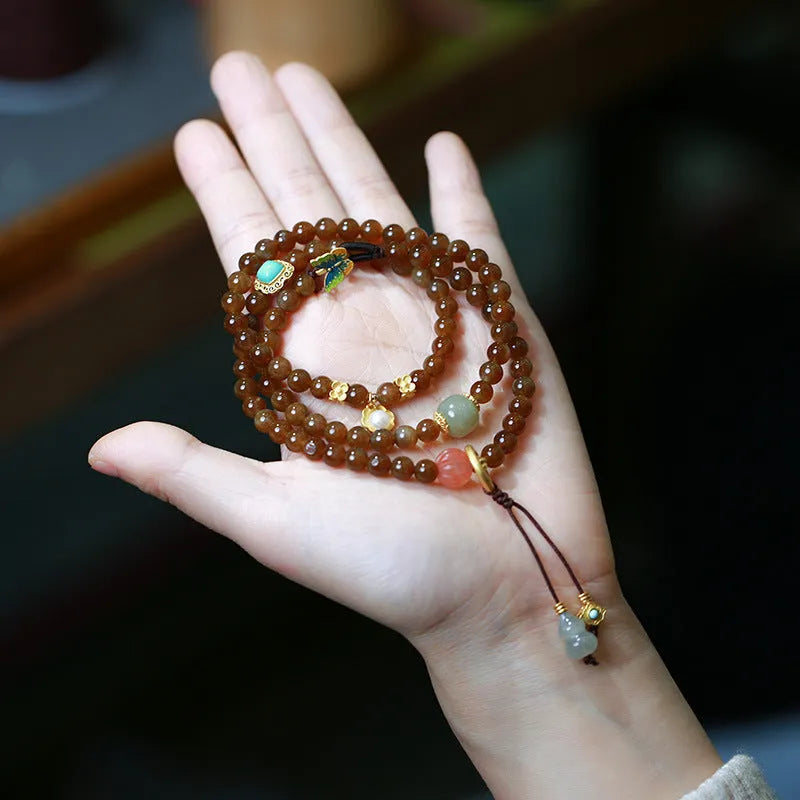 Brown Jade Hetian jade bracelet with butterfly, gourd, and pearl three-ring design and silver-plated fittings.