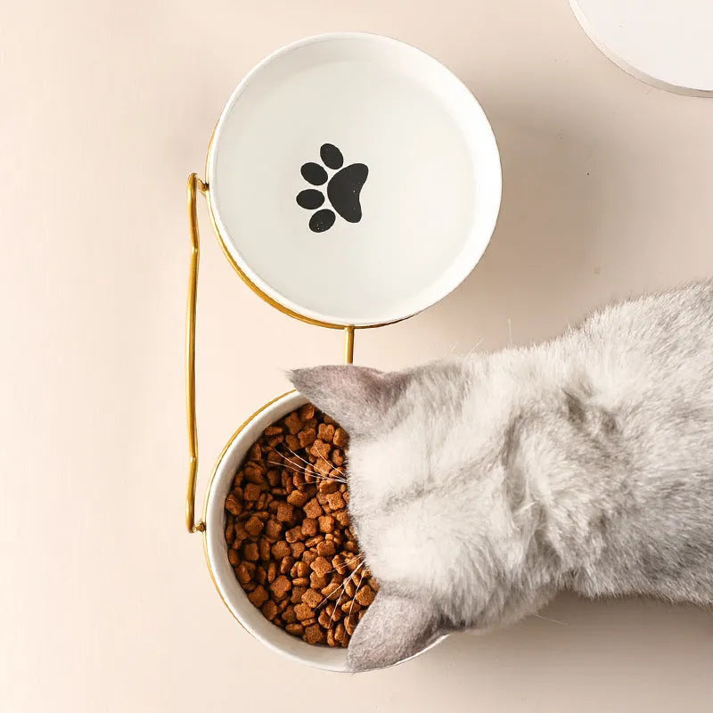 Pure white ceramic cat bowl with cat footprints design on a black iron frame stand with cat ears.