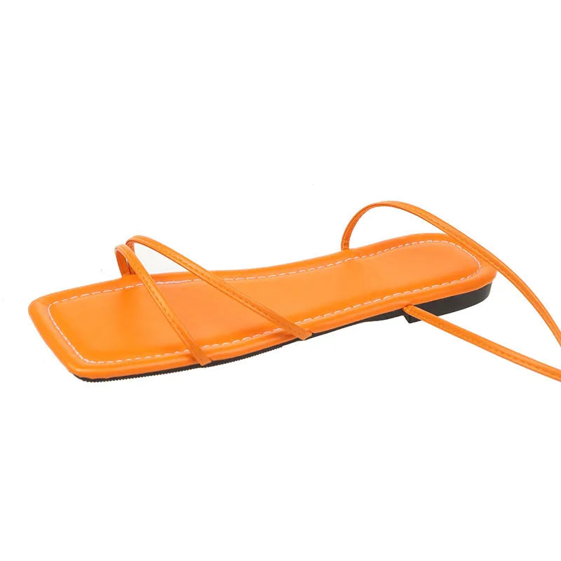 Women's flat sandals with ankle strap and front lace-up fastening in square toe design.