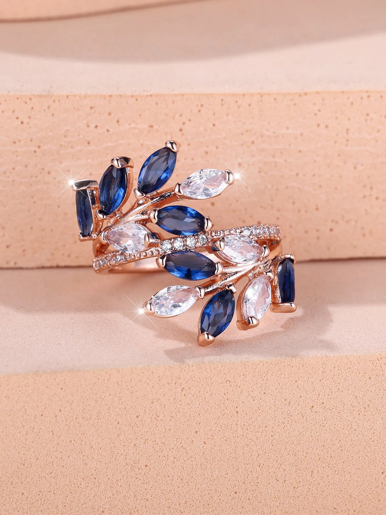 Adjustable open-ended leaf-shaped ring with zirconia stones on a copper band.